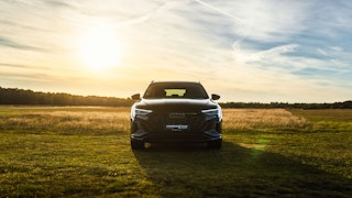 Audi SUV im Abendlicht auf freiem Feld Schwarzer Audi SUV im Abendlicht auf freiem Feld