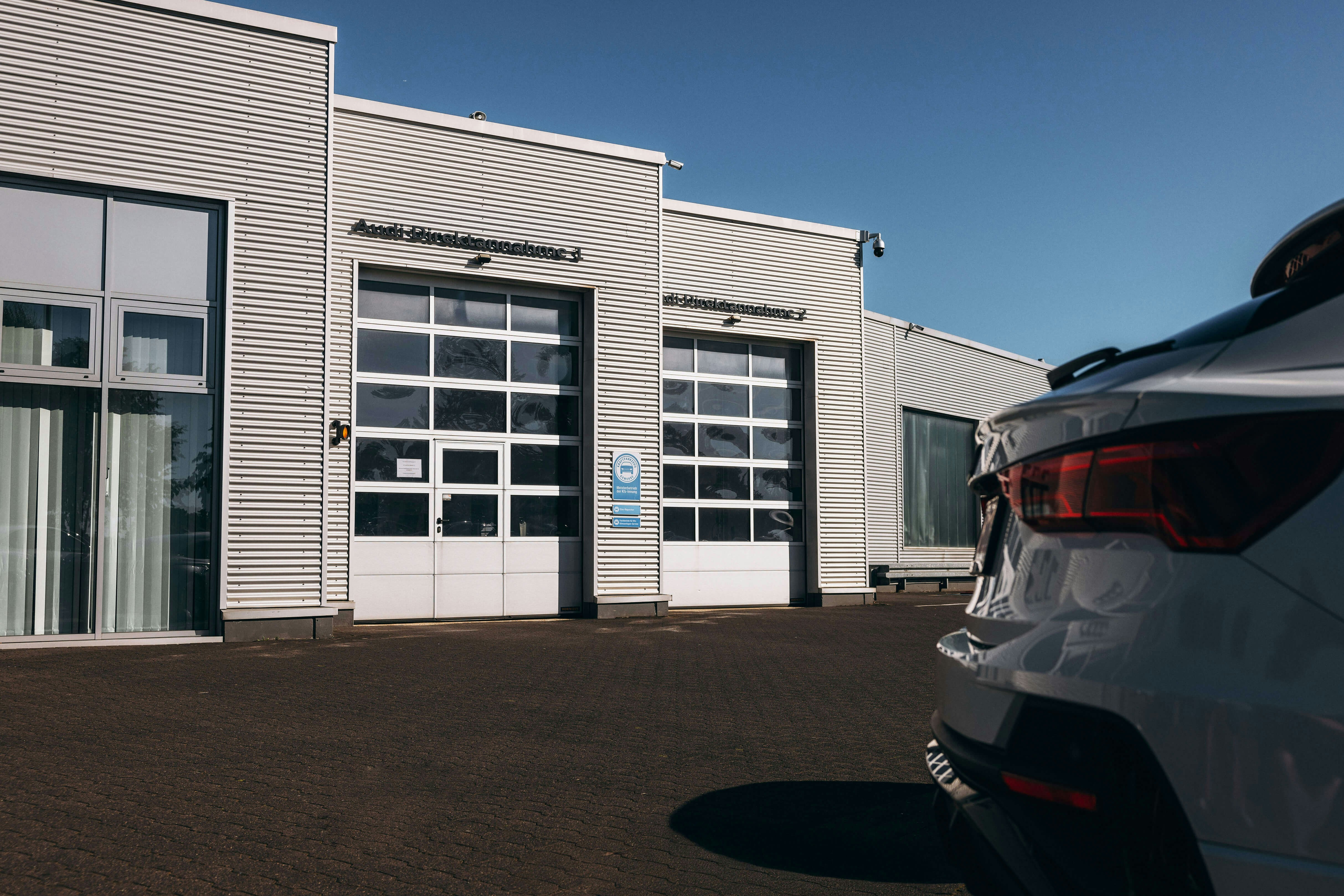Audi Werkstatt vom Schröder-Team – zertifizierter Servicepartner Außenansicht der Audi Werkstatt mit geöffnetem Servicebereich und Audi Fahrzeug im Vordergrund