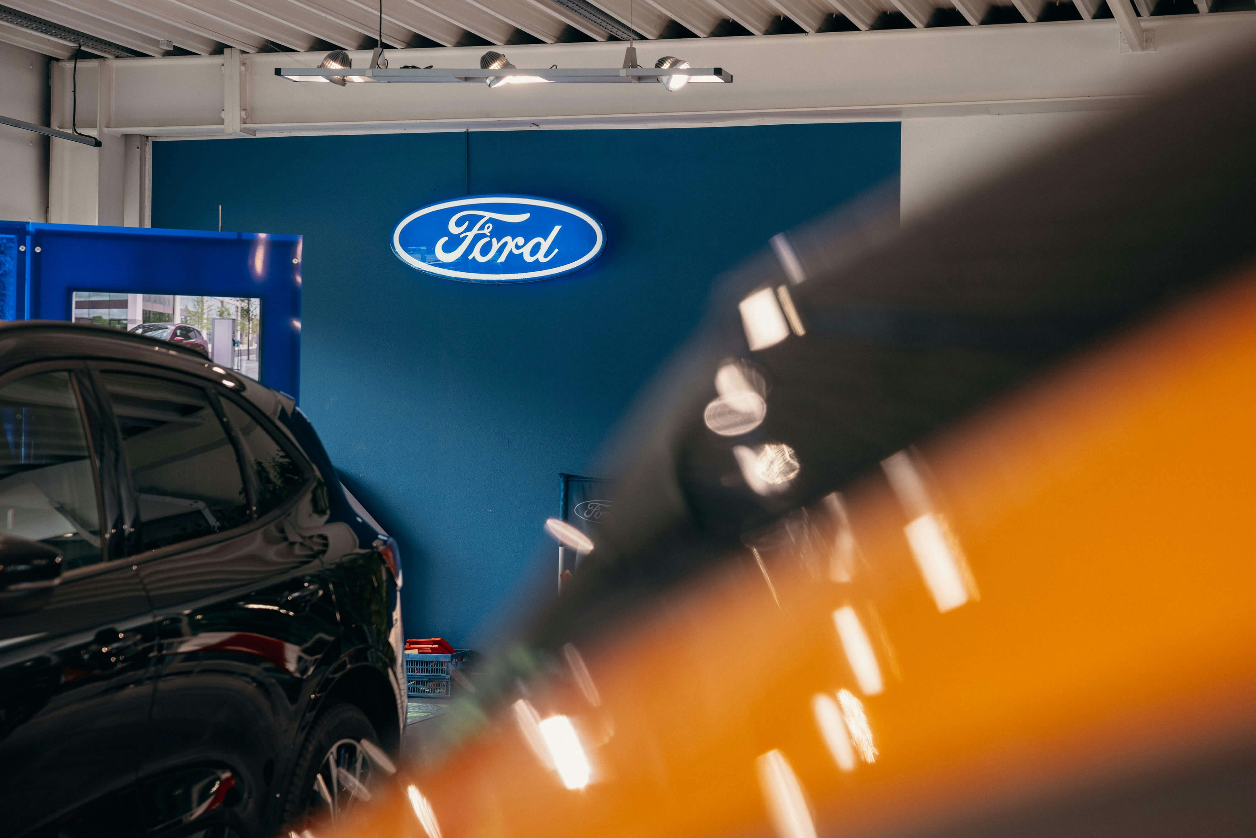 Ford Angebote im Autohaus – entdecken Sie die neuesten Modelle im Showroom. Ford Showroom mit leuchtendem Markenlogo und aktuellen Fahrzeugangeboten.