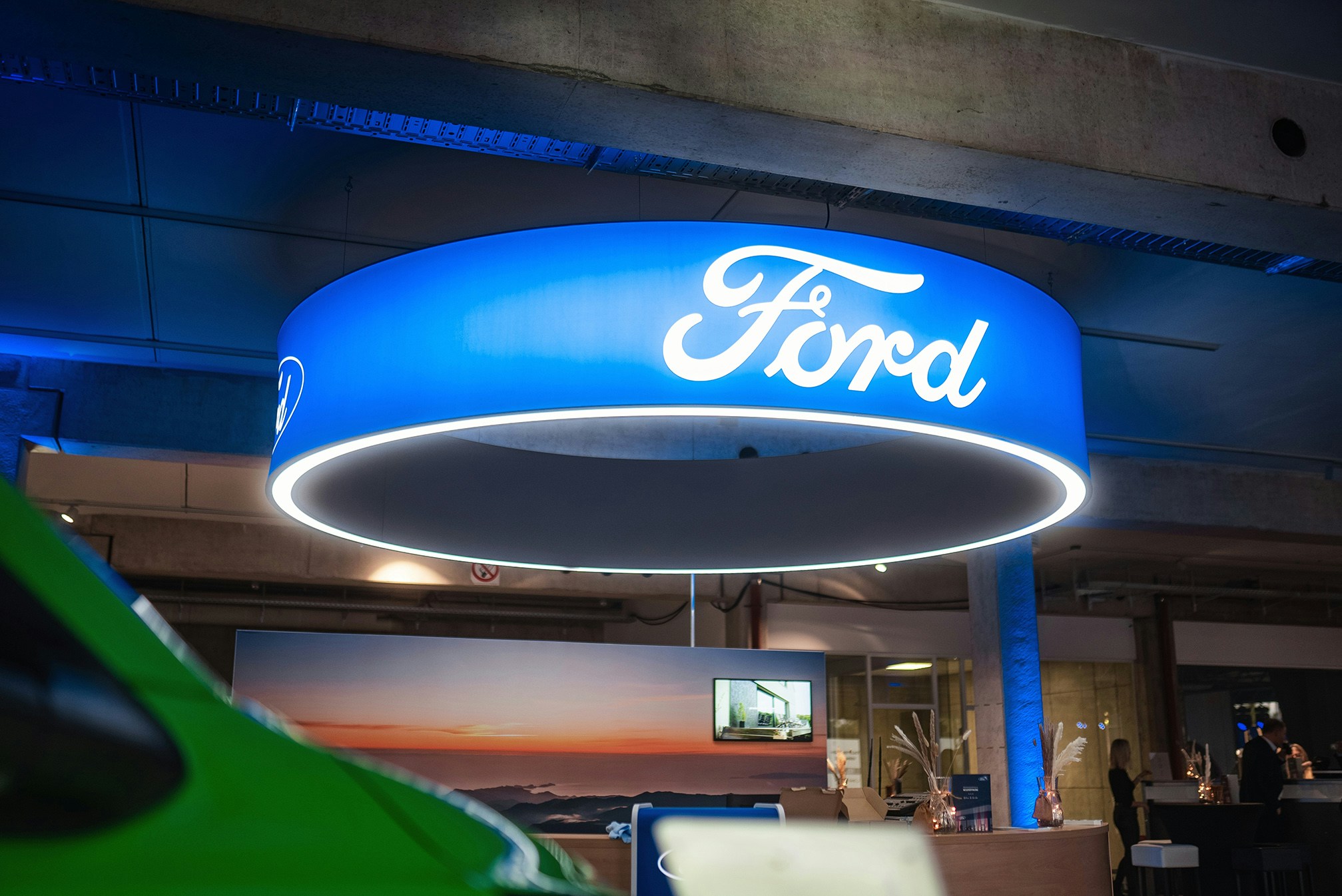 Ford Autohaus – Markenpräsenz mit stilvoll beleuchtetem Logo im Showroom. Leuchtendes Ford Logo in einem modernen Autohaus oder Ausstellungsraum.