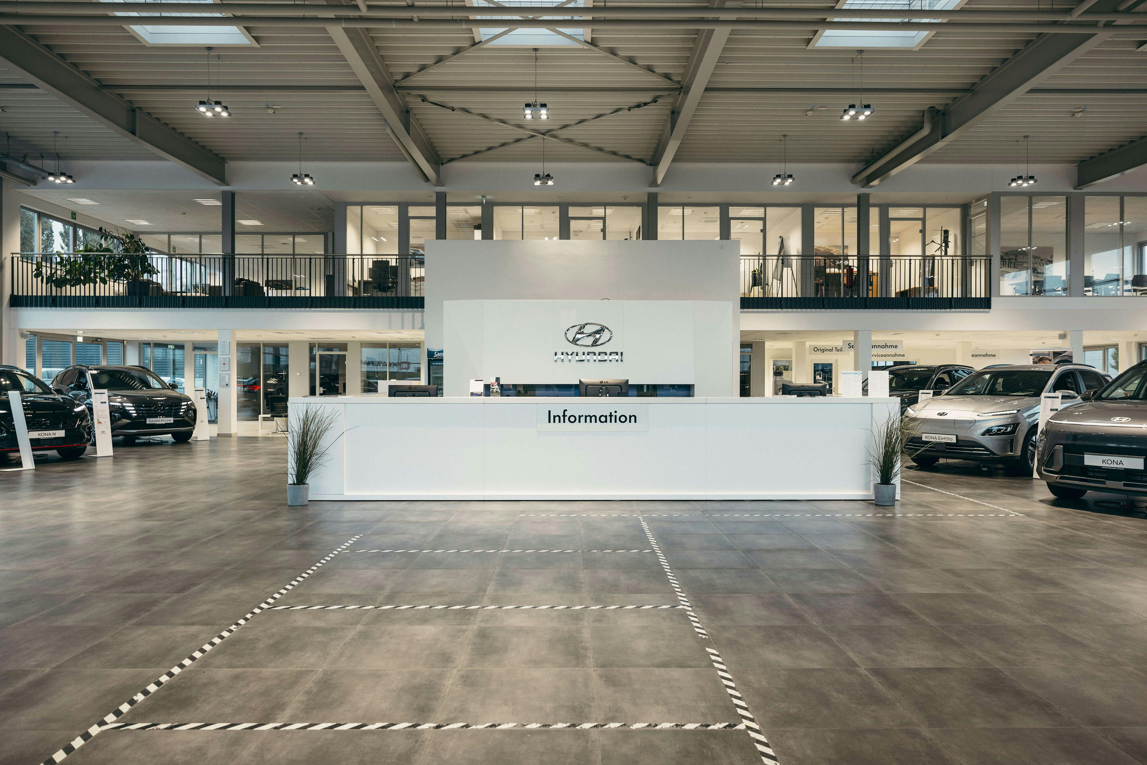 Hyundai Autohaus – zentrale Anlaufstelle und moderne Fahrzeugpräsentation. Heller Empfangsbereich im Hyundai Autohaus mit Informations-Counter und ausgestellten Modellen.