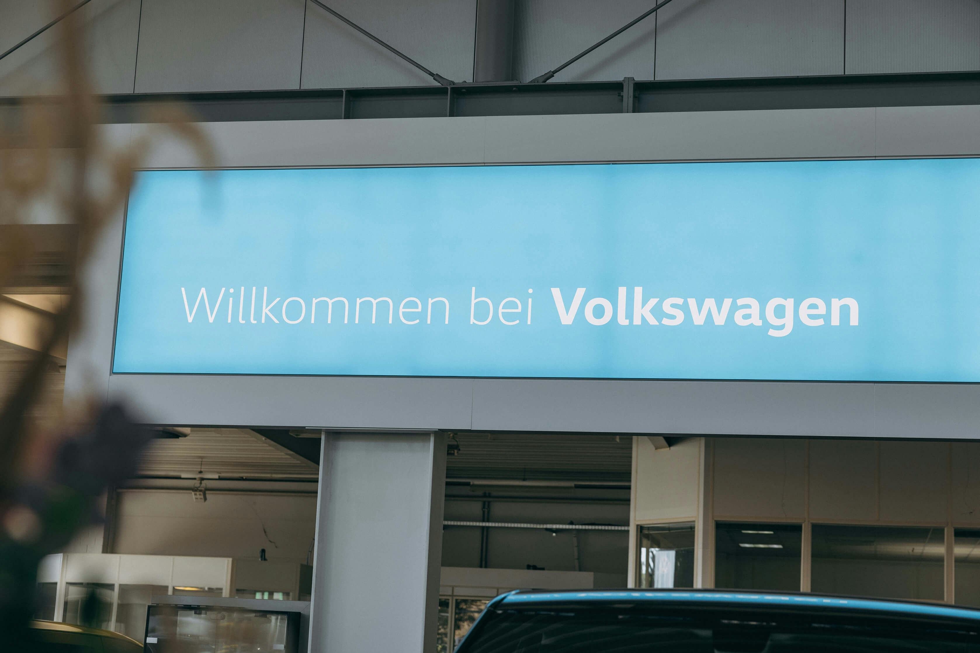 Schriftzug Willkommen bei Volkswagen Schriftzug Willkommen bei Volkswagen weiß auf hellblau