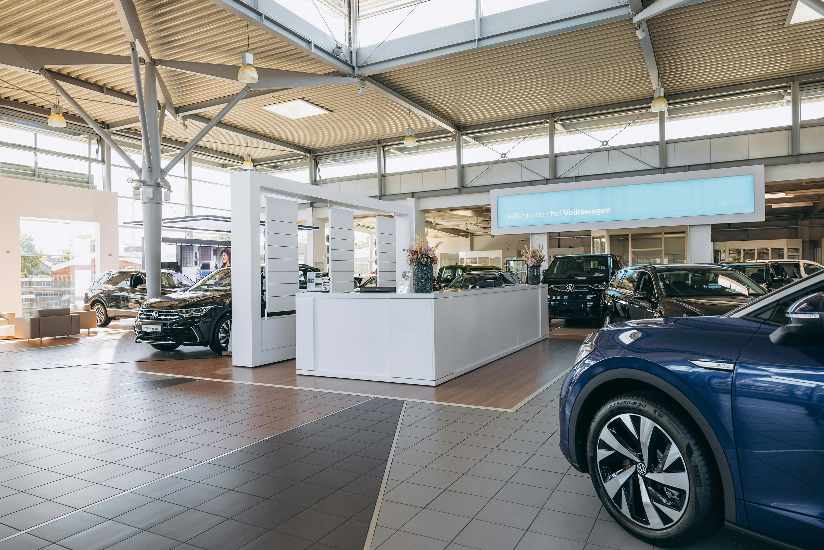VW Finanzierung direkt im Autohaus – Beratung und Angebote vor Ort Innenbereich des VW Autohauses mit Beratungstheke und Neuwagen für Finanzierungsgespräche
