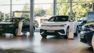 VW Neuwagen im Autohaus – Fahrzeug im modernen Schauraum VW Neuwagen im hellen Autohaus-Ausstellungsraum mit Tageslicht