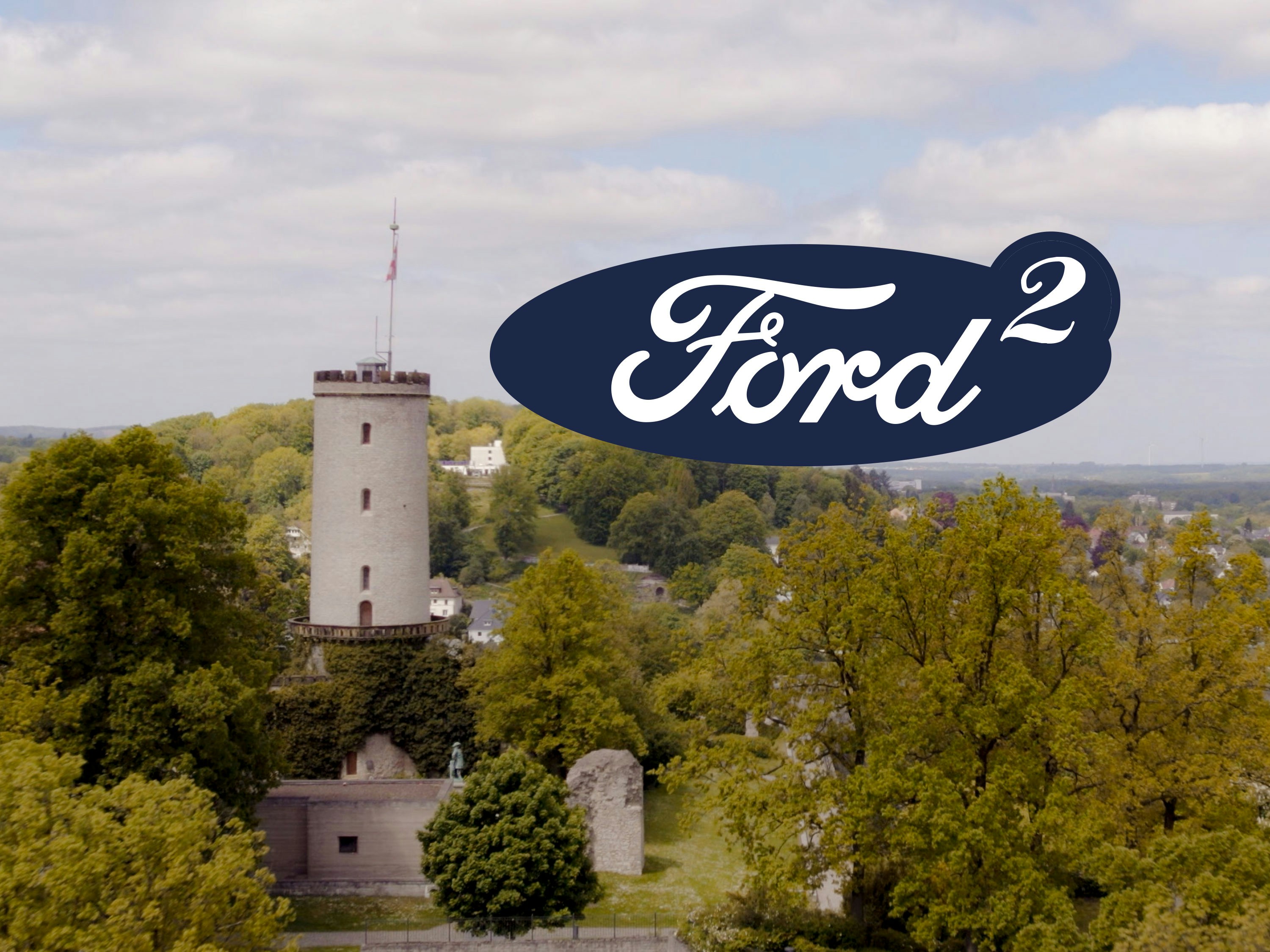 2x Ford in Bielefeld Logo mit ergänzter 2, die die 2 Standorte in Bielefeld symbolisiert. Im Hintergrund ist die Sparrenburg zu sehen
