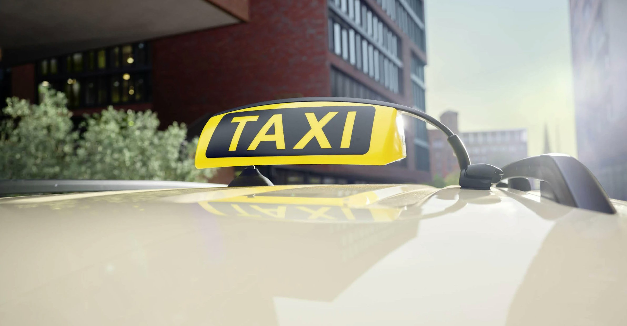 Taxi bereit zur Abfahrt – mobil in der Stadt unterwegs! Nahaufnahme eines Taxi-Schilds auf dem Fahrzeugdach vor moderner Stadtarchitektur bei Tageslicht.
