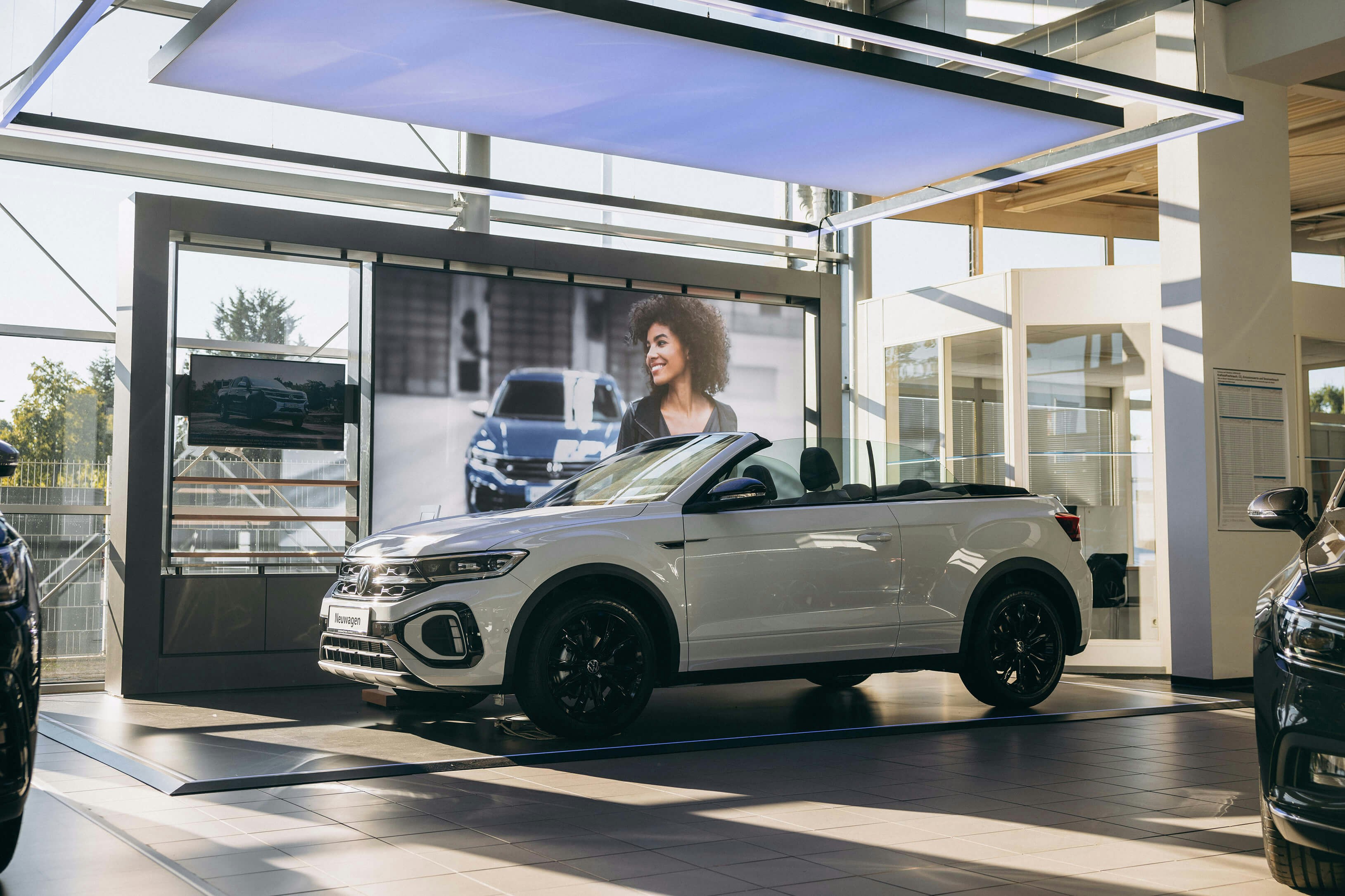 VW Leasing für Neuwagen – Cabrio im Showroom entdecken Weißes VW T-Roc Cabrio im Autohaus Schauraum – attraktives Fahrzeug für VW Leasingkunden
